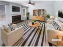 Bright living room featuring a fireplace, ceiling fan, and modern decor for a comfortable space at 2208 Howell Farms Nw Pt, Acworth, GA 30101