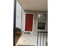 Condo entrance with red door, gray siding, and black railing with small bushes near the entry at 4351 Timberlake, Stone Mountain, GA 30083