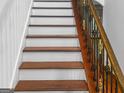 Elegant staircase with decorative iron railings and rich wood accents at 5589 Dendy Trace, Fairburn, GA 30213