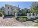 Stately two-story home boasts a manicured lawn, brick driveway and wrought iron fence at 115 17Th Ne St, Atlanta, GA 30309