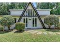 A-frame home with an inviting front entrance and glass inserts, complemented by lush landscaping at 4253 Smithsonia Dr, Tucker, GA 30084