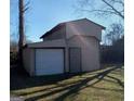 Large detached garage with an open storage space, a roll-up door, and a standard entry door at 6258 Mount Zion Blvd, Morrow, GA 30260