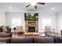 Cozy living room featuring a stone fireplace with mounted TV, hardwood floors, and comfortable seating at 165 Ruby Ln, Mcdonough, GA 30252