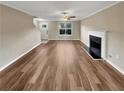 Well-lit living room featuring a fireplace, large window and hardwood floors at 166 Floresta Dr, Mcdonough, GA 30252