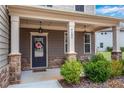 Inviting front porch with stone accents, decorative wreath, and well-maintained landscaping at 4080 Huron Dr, Cumming, GA 30028