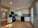 Well-lit kitchen boasts white cabinets, stainless appliances, and hardwood flooring at 1007 Burton Nw Ct, Kennesaw, GA 30152