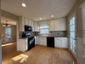 Well-lit kitchen boasts white cabinets, stainless appliances, and hardwood flooring at 1007 Burton Nw Ct, Kennesaw, GA 30152