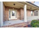 Covered front porch featuring brick columns, white railing, and a charming front door with glass panels at 847 Sand Ln, Lawrenceville, GA 30045