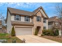 Charming two-story home featuring an attached garage, well-maintained lawn, and a blend of stone and siding at 1077 Roanoke Ave, Mcdonough, GA 30253
