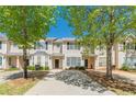 Charming two-story townhome with a well-maintained driveway and landscaping, set against a bright blue sky at 2454 Brianna Dr, Hampton, GA 30228