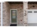 Close up of the entryway with brick surround, decorative door and garage door at 403 Inglenook Walk, Marietta, GA 30060
