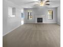 Spacious carpeted living room with fireplace and large windows providing natural light at 5158 Summersun Dr, Morrow, GA 30260