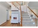 Bright foyer with hardwood floors, coat nook, staircase with wooden handrail and white balusters, and neutral decor at 5569 Snowy Orchid Dr, Sugar Hill, GA 30518