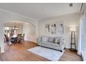 Inviting living room with hardwood floors, neutral paint, elegant archway into the dining room, and sofa at 5569 Snowy Orchid Dr, Sugar Hill, GA 30518