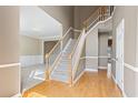 Bright foyer with hardwood floors, a staircase with white railings, and views into adjacent living spaces at 1390 Bridle Path Dr, Lawrenceville, GA 30045