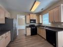 Well-lit kitchen with stainless steel appliances and wood-look flooring at 2728 Sandalwood Cir, Locust Grove, GA 30248