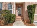 Inviting front entrance with brick steps, a decorative door, and manicured bushes at 5720 Stow Dr, Tucker, GA 30084