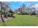 This lovely home has a large, well-manicured lawn and mature trees surrounding the property at 820 Thermopylae Ct, Alpharetta, GA 30005
