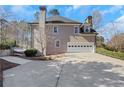View of the home featuring an attached garage and a well-maintained driveway at 820 Thermopylae Ct, Alpharetta, GA 30005