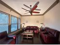 Comfortable living room with multiple windows, ceiling fan, and dark leather furniture at 745 Fountainhead Ne Ln # 130, Atlanta, GA 30324