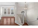 View of the foyer with hardwood floors, staircase, decorative lighting and view into the adjacent living room at 2782 Loftview Sq, Atlanta, GA 30339