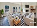 Bright living room with fireplace, two white sofas, large windows, and french doors to outdoor deck at 1200 Platinum Dr, Hoschton, GA 30548