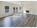 Bright and airy living room featuring a fireplace, hardwood floors, two windows, and french doors at 1200 Platinum Dr, Hoschton, GA 30548