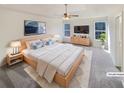 Well-lit main bedroom with plush gray carpet, tray ceiling, ceiling fan, and two windows at 1200 Platinum Dr, Hoschton, GA 30548