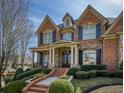 Beautiful brick home featuring a covered front porch and meticulously landscaped front yard at 3180 Wills Mill Rd, Cumming, GA 30041