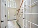 Inviting foyer with tile flooring, staircase, high ceilings, and lots of natural light at 76 Barrington Farms Pkwy, Sharpsburg, GA 30277