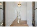 Inviting hallway features pristine white walls with dark trim and beautiful natural wood flooring at 204 Wakehurst Way, Marietta, GA 30064