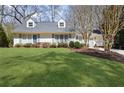 Beautiful house with dormer windows, gray shutters, complemented by a well-manicured green lawn and landscape at 2553 Ridgewood Nw Ter, Atlanta, GA 30318