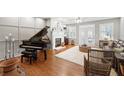 Elegant living room with hardwood floors, fireplace, and grand piano at 4364 Grove Field Ct, Suwanee, GA 30024