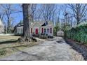 Cozy home with a driveway leading to a detached garage, surrounded by mature trees and lush greenery at 2953 Hardman Ne Ct, Atlanta, GA 30305