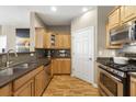 Well-lit kitchen featuring stainless steel appliances, tile backsplash, wooden cabinets, and hardwood floors at 4805 W Village Se Way # 2108, Smyrna, GA 30080