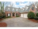 Inviting brick home with a two-car garage and manicured front yard at 1207 Woodlawn Ne Dr, Marietta, GA 30068