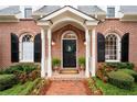 Close-up of a brick home's front door with black shutters and a decorative wreath at 1207 Woodlawn Ne Dr, Marietta, GA 30068