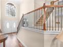 Elegant foyer featuring wood floors, a staircase with iron railings, and double doors with arched windows at 8116 Powhattan Ct, Mcdonough, GA 30252