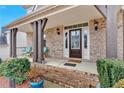 Inviting front porch featuring brick accents, sturdy columns, and comfortable seating, creating a welcoming entrance at 108 Rex Ave, Canton, GA 30114