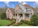 Beautiful brick home with covered front porch, stone accents and manicured landscaping with green lawn at 4865 Meadow Park Ln, Suwanee, GA 30024