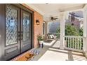Inviting covered front porch with porch swing, stylish double doors, and brick facade at 4865 Meadow Park Ln, Suwanee, GA 30024