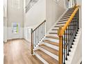 Grand foyer features hardwood floors, elegant staircase with iron spindles, and wainscoting at 3114 Thicket Ln, Atlanta, GA 30349