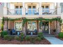 Charming covered front porch with seating, lush greenery, and double front doors at 219 Dawson Dr, Woodstock, GA 30188