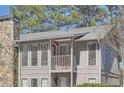 Exterior view highlighting a balcony and stone chimney of a multi-story condo building at 3852 Woodridge Way, Tucker, GA 30084