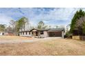 View of the exterior of the home, featuring painted brick, a covered front porch, and an attached carport at 2177 American Legion Rd, Dacula, GA 30019