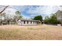 Single-story home features a painted brick exterior, black trim, and attached carport in a spacious yard at 2177 American Legion Rd, Dacula, GA 30019