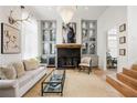 Bright living room featuring a fireplace, built-in cabinets, hardwood floors, and stylish decor at 11279 Serenbe Ln, Chattahoochee Hills, GA 30268