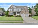 Beautiful two-story brick home featuring a well-maintained lawn, two-car garage, and inviting front entrance at 3286 Sweetleaf Ln, Buford, GA 30519