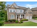Beautiful two-story brick home with manicured lawn, welcoming entrance, and attached two-car garage at 3286 Sweetleaf Ln, Buford, GA 30519