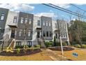 Modern townhome with white brick, gray panels, black framed windows, and black iron fences and stairs at 1098 Briar Cove Cir, Atlanta, GA 30329